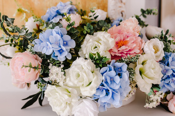 Big bouquet of fresh flowers, pink, blue hydrangeas, white roses and greenery in vase. Wedding flowers, bridal bouquet closeup. Home decor on table, vintage style. Decoration objects.