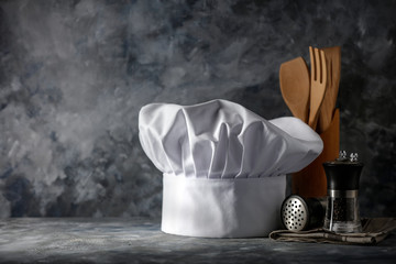 White cook hat on desk and kitchen interior.Free space for your decoration. 