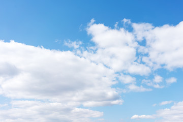 Naklejka na ściany i meble White cumulus clouds against the background against blue on a blue background.