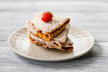 Waffles and strawberries on a grey wooden background. Dessert with berries.