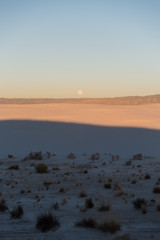 Full moon during sunset at White Sands National Park in Alamogordo, New Mexico. 