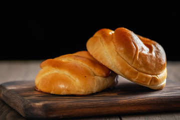 Fresh and rosy buns with cherry on a wooden table
