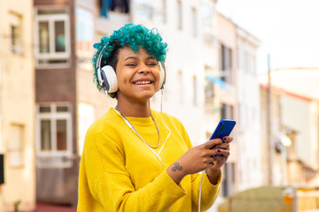 young girl with mobile phone and headphones outdoors in the city