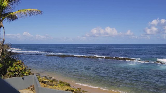 Ocean view landscape from shore - blue waves and stones in water, San Juan, Puerto Rico