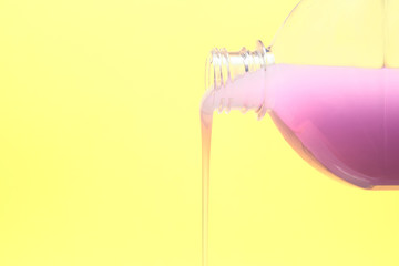liquid purple soap flows from a plastic bottle