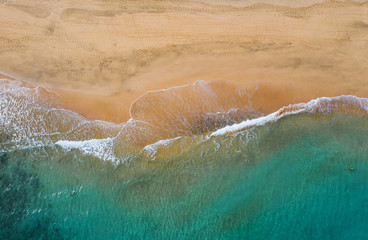 Fototapeta na wymiar Sea water meeting white sand beach - aerial view. Fuerteventura island, Canary, Spain. October 2019