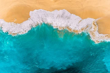 Gordijnen Aerial view of turquoise ocean waves in Kelingking beach, Nusa penida Island in Bali, Indonesia. Beautiful sandy beach with turquoise sea. Splashing ocean waves reach sandy beach. Beaches of Indonesia © MISHA