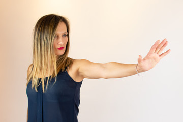 Young woman with straight arm making the stop gesture