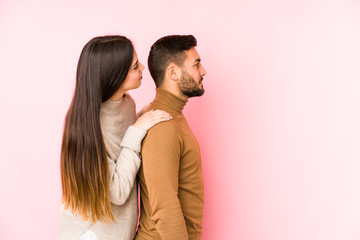 Young caucasian couple isolated gazing left, sideways pose.
