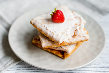  Waffles and strawberries on a grey wooden background. Dessert with berries.