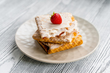  Waffles and strawberries on a grey wooden background. Dessert with berries.