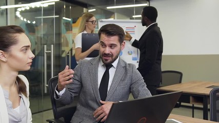 Front view of professional enterprising bearded businessman which emotionally telling to his considerate female colleague about opportunities about better results of their joint project on the