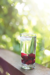 Cold refreshing water with cherry and ice.