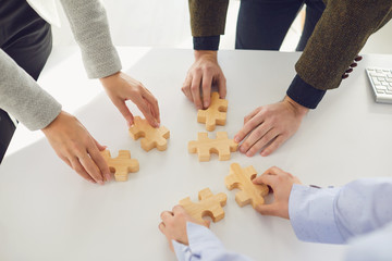 Faceless business people placing puzzles idea together