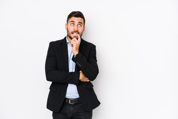 Young caucasian business man against a white background isolated relaxed thinking about something looking at a copy space.