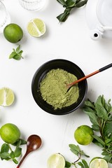 Vertical shot of matcha and limes on a white background