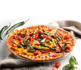 The concept of Italian cuisine. Vegetable pizza with tomatoes, peppers, corn and asparagus on a light background. Background image, copy space