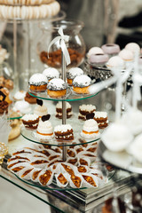 Stylish beautiful luxury sweet candy bar set on the table at the wedding ceremony in restaurant. Tasty desserts on the table. Confectionery business concept.