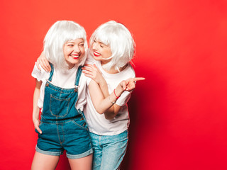 Two young sexy smiling hipster girls in white wigs and red lips.Beautiful trendy women in summer...