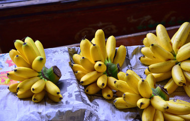 Beautiful composition of tropical fruits on the background of a wooden boat- yellow bananas and...