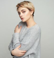 Portrait of sexy young woman with short hair isolated on gray background