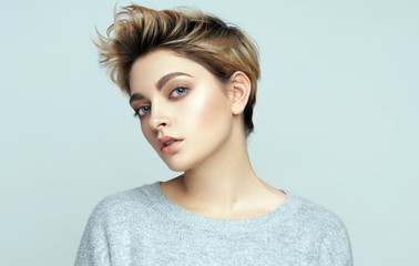 Portrait of sexy young woman with short hair isolated on gray background