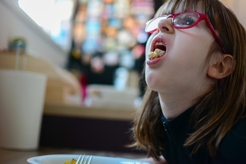 Close-up, side view of Spoiled pretty kid girl refusing to eat her dinner. Impaired small girl...