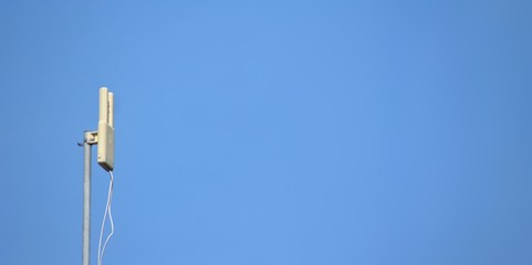 Internet 5G antenna on blue sky background.