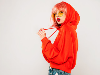 Young beautiful hipster bad girl in trendy red summer hoodie and earring in her nose.Sexy carefree...
