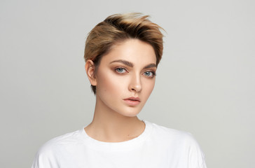 Portrait of young model with short hair isolated on gray background
