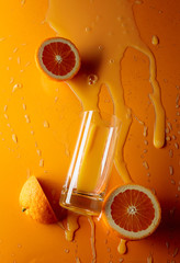 Orange juice with fruits on a orange background.