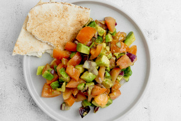 Healthy food. Avocado and tomato salad with red onions, flat lay vegan salad.