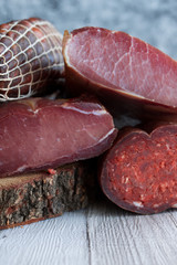 Cold smoked meat on dark background.