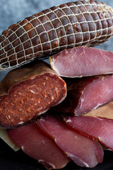 Cold smoked meat on dark background.