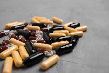 Different capsule pills on a gray background close-up.
