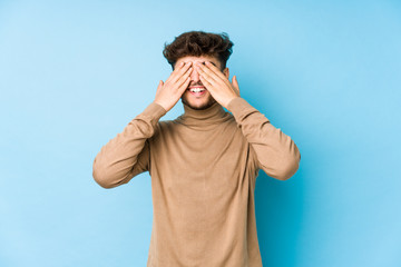 Young arabian man isolated covers eyes with hands, smiles broadly waiting for a surprise.