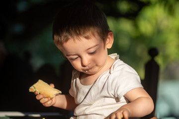 Child drinks alone eating bread inside his house