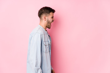 Young caucasian business man posing in a white background isolated shouting towards a copy space< mixto >