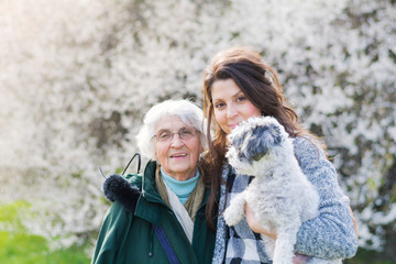 Happy Family with  Dog in the Spring Park .Family Portrait of Grandmother and Granddaughter with Dog