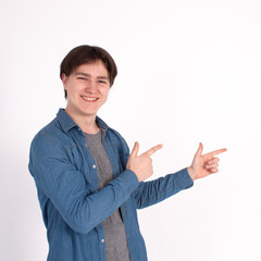 young man nerd pointing finger aside at blank copy space, isolated on white grey studio background.