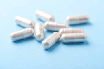 Carnitine capsules. Concept for a healthy dietary supplementation. Bright paper background. Soft focus. Close up.
