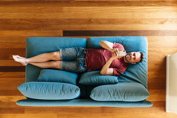 Fototapeta na wymiar Casual guy on armchair with smartphone