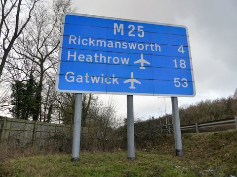 M25 motorway sign at Micklefield Green, Hertfordshire showing distances to Rickmansworth, Heathrow Airport and Gatwick Airport