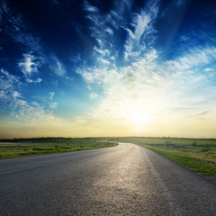 sunset in deep blue sky over asphalt road