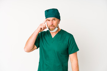 Surgeon senior man isolated on white background showing a disappointment gesture with forefinger.