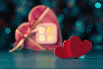 Two red hearts over defocused house with light in window. Valentines day concept