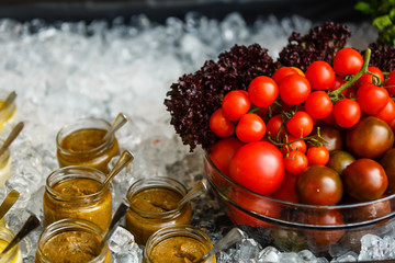 Juicy spicy marinated tomatoes on a white plate. Green fir branches. On a light background, top view.