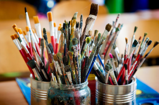 A lot dirty artist paint brushes in a bucket