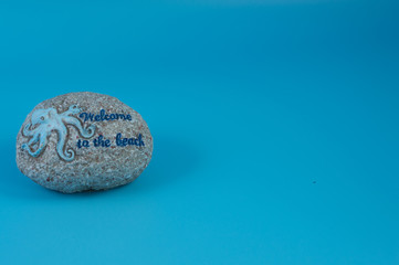 Round ornamental stone with octopus and welcome message, with gray background