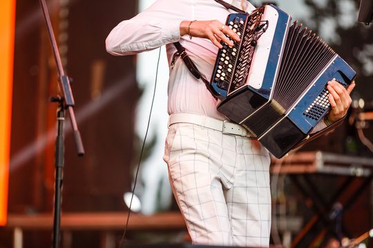Male playing on the accordion against a grunge background